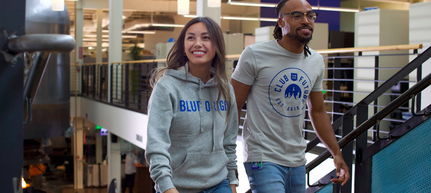 Blue Origin professionals in casual Store apparel exploring a modern office space with open-plan design and industrial elements, highlighting a collaborative and contemporary work environment.